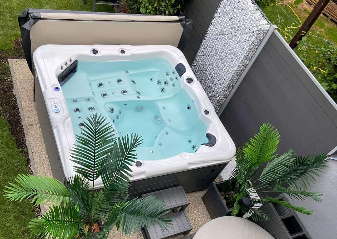 Freistehender Whirlpool in einem Garten, von schräg oben gesehen