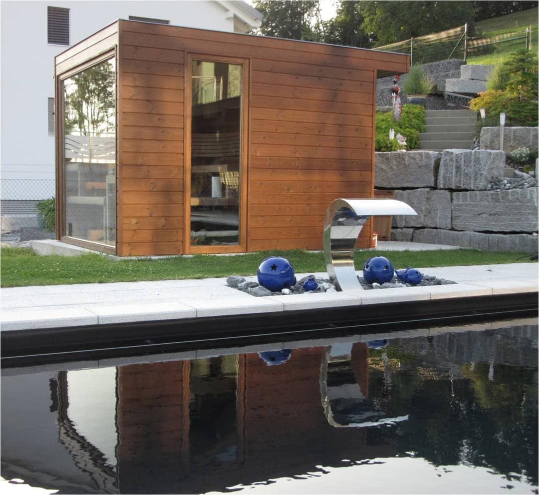 Gartensauna aus Holz mit Glasfront an einem Pool