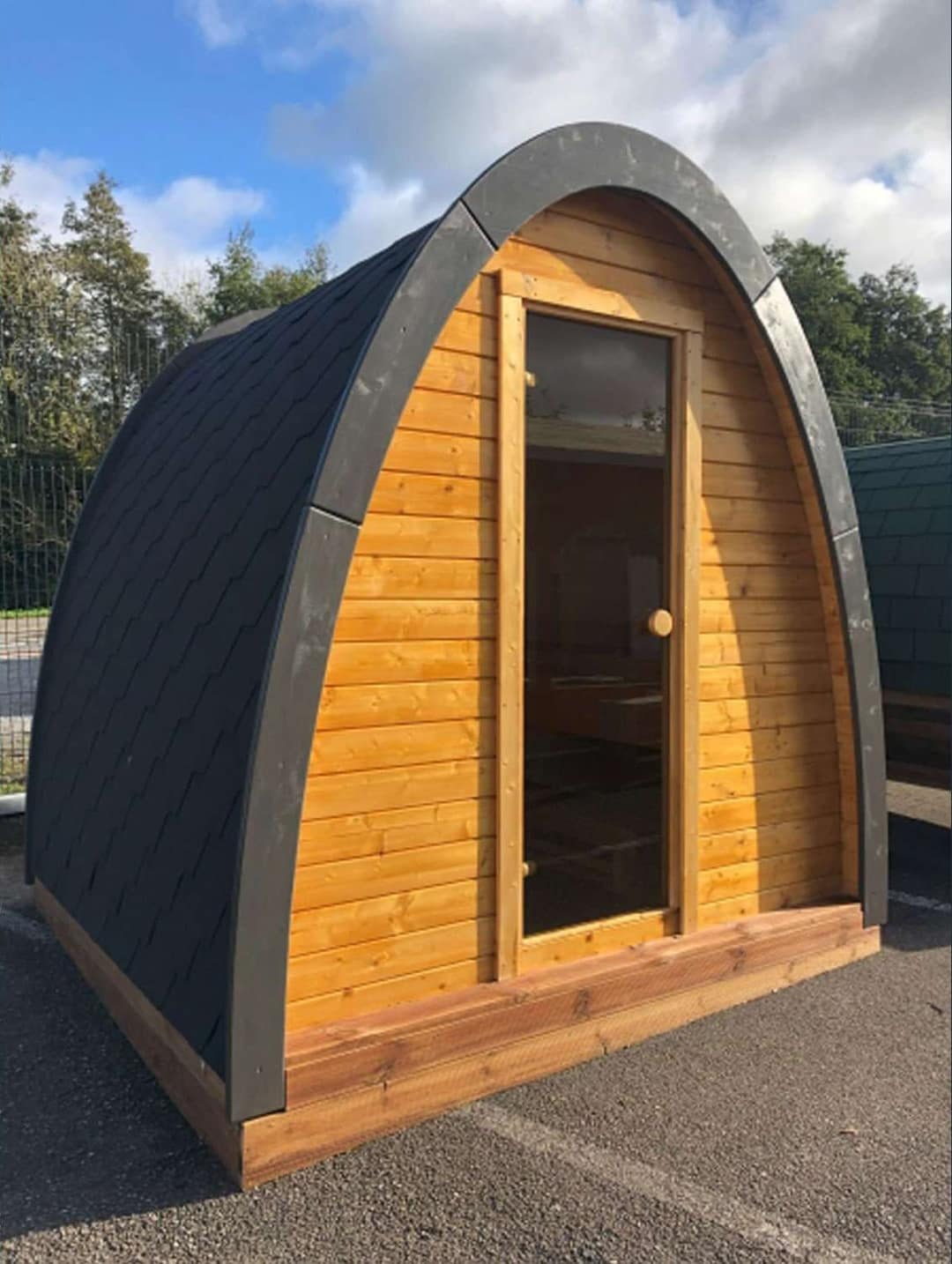 Sauna Pod aus Holz mit gewölbtem Dach und Glastür
