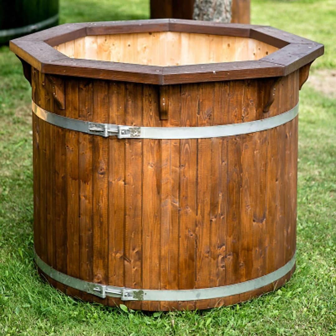 Tauchzuber aus dunklem Holz mit zwei Metallbändern, im Gras stehend
